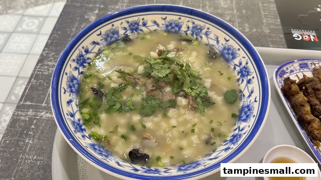 A hearty bowl of traditional Xi'an soup with meat and herbs, alongside grilled skewers.