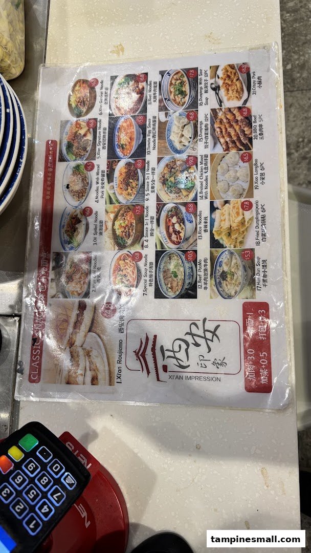 A laminated menu displaying various Xi'an cuisine dishes with prices and images.