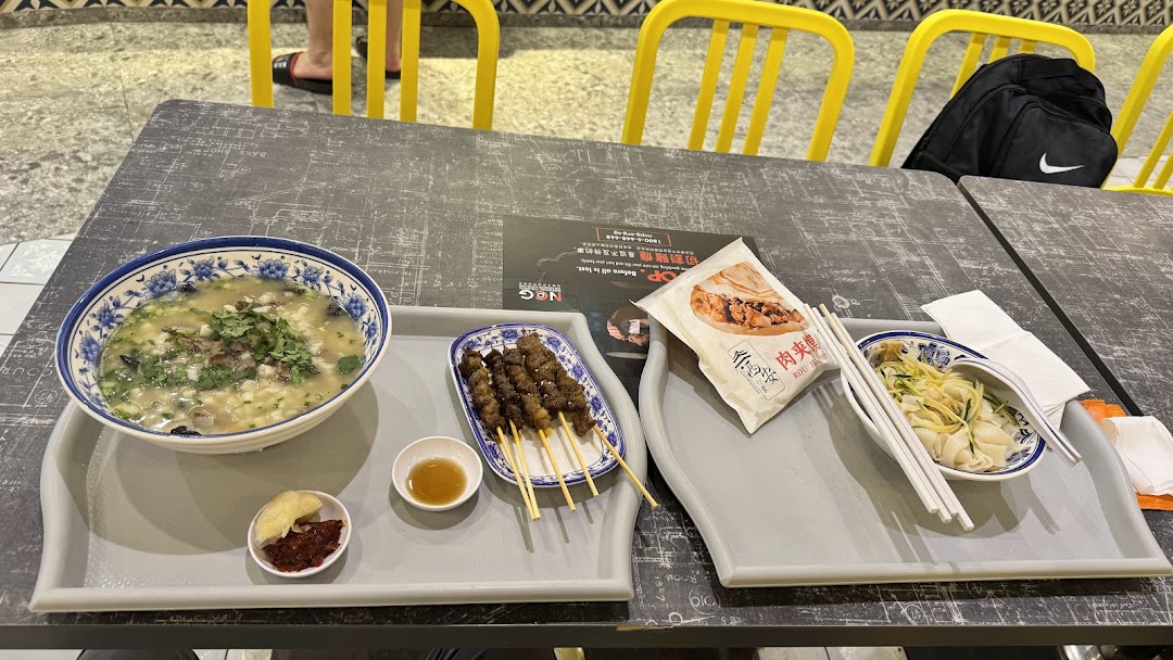 A table laden with various delicious Xi'an dishes, including soup, skewers, and noodles.