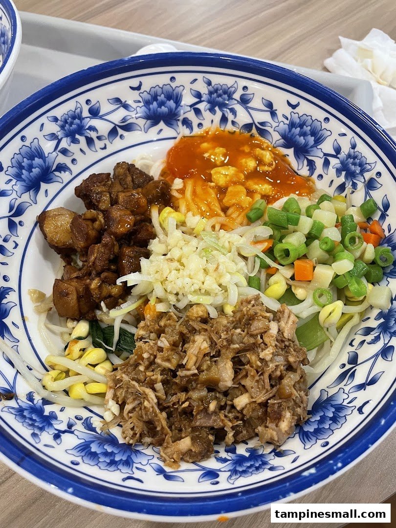 A vibrant bowl of Xian noodles with braised pork, minced meat, fresh vegetables, and spicy sauce.
