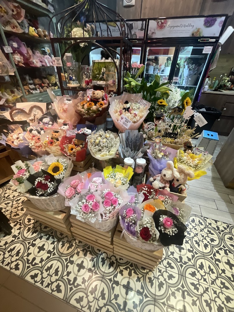 A vibrant display of various flower bouquets and arrangements, including roses, sunflowers, and plush toys, inside Xpressflower.