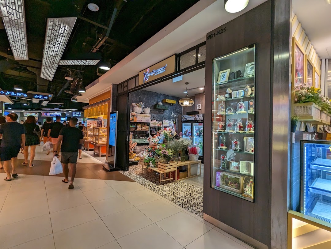 The shopfront of Xpressflower, a vibrant flower and gift shop, is seen within a busy shopping mall.