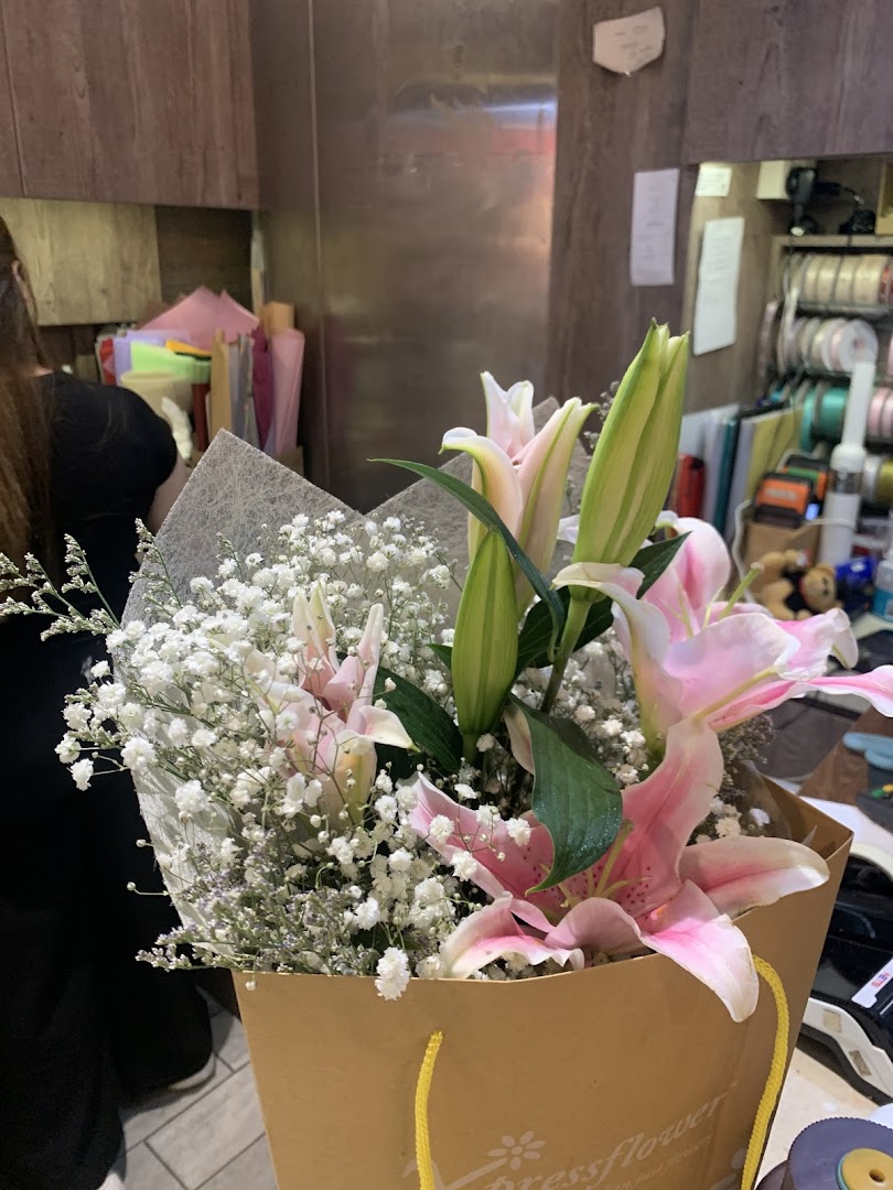 A beautiful bouquet of pink lilies and baby's breath in an Xpressflower bag, inside the shop.