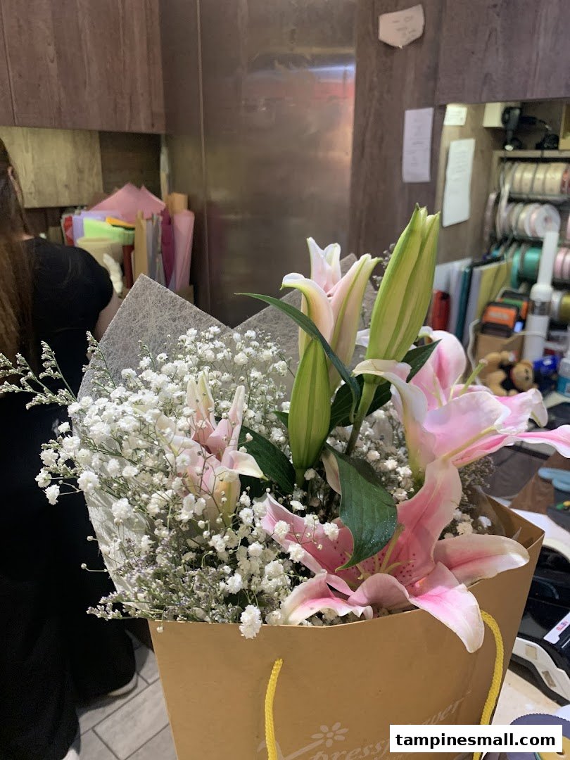 A beautiful bouquet of pink lilies and baby's breath in an Xpressflower bag, inside the shop.