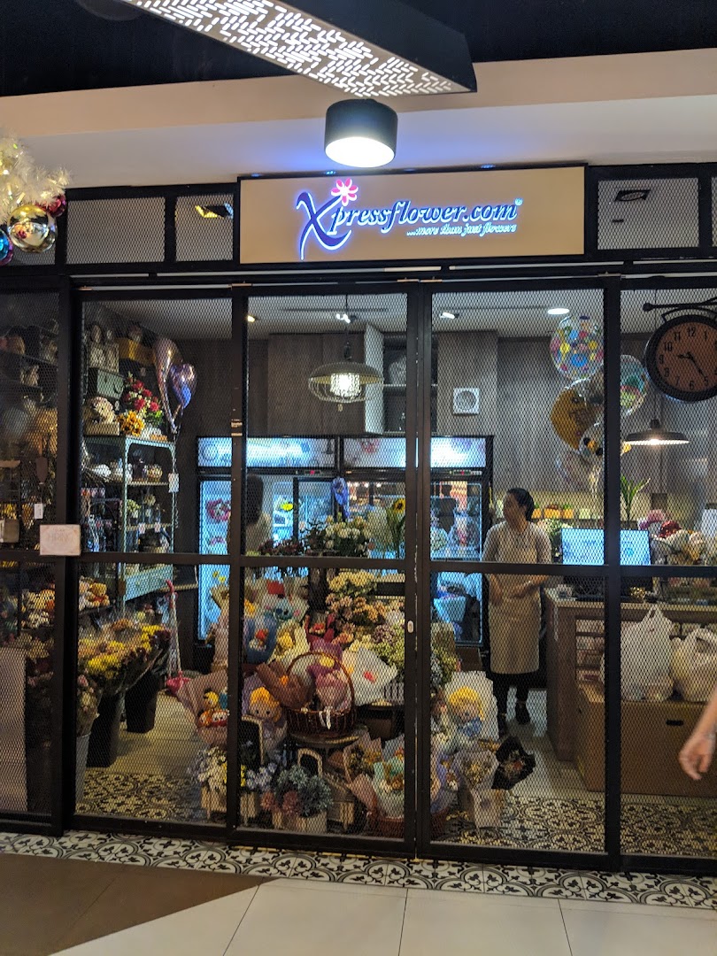 The storefront of Xpressflower, a vibrant flower and gift shop, showcasing colorful arrangements and balloons.