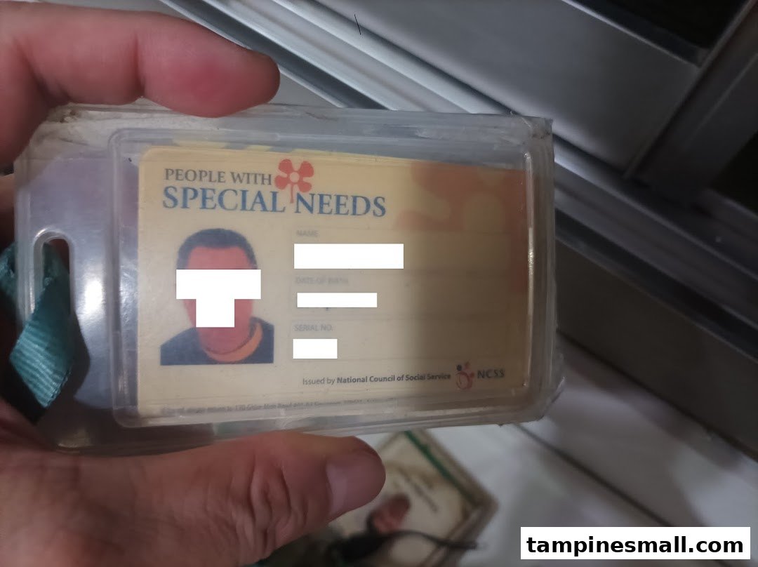 A hand holds an ID card for 'People with Special Needs' issued by NCSS.