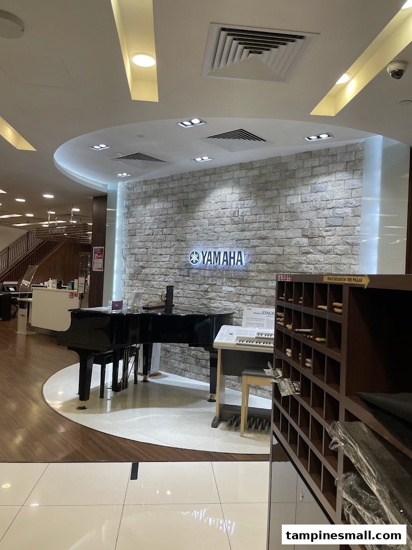 Interior view of Yamaha Music School featuring a grand piano, keyboards, and a brick-textured wall with the Yamaha logo.