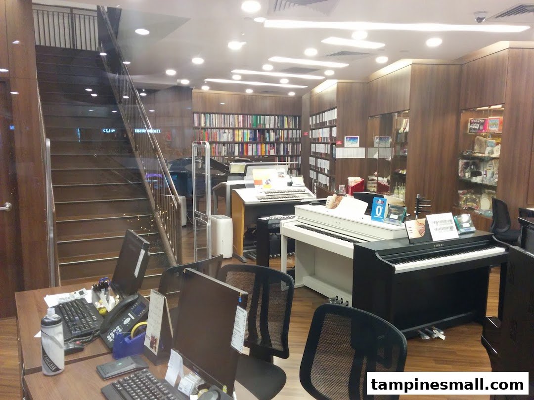 Interior view of Yamaha Music School, featuring pianos, keyboards, sheet music, and a reception desk.