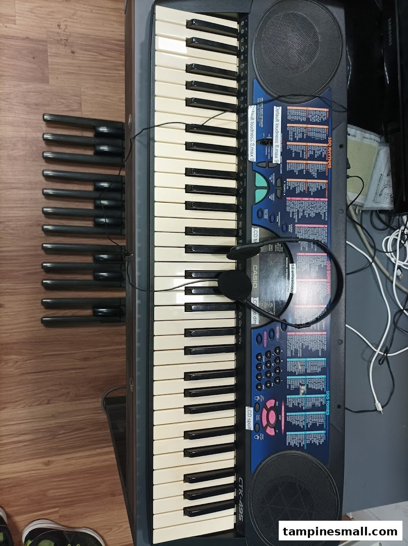 A Casio keyboard with headphones and organ pedals, set up for music practice.