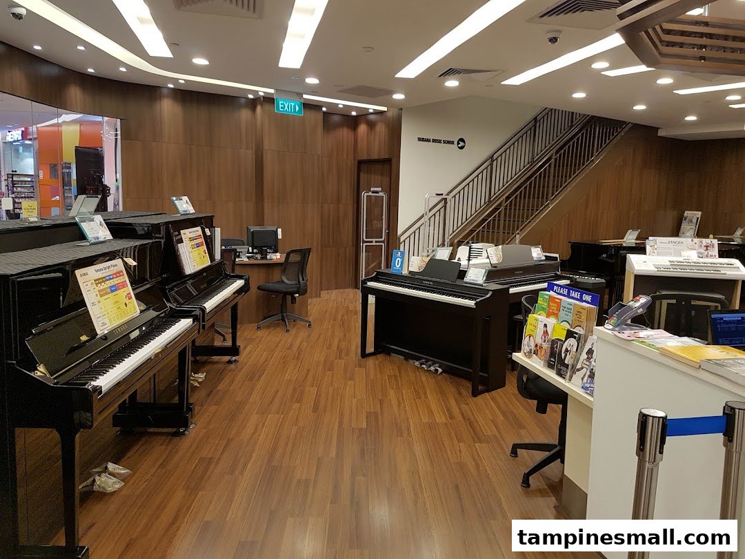 Interior view of Yamaha Music School showcasing various pianos, keyboards, and a reception area.