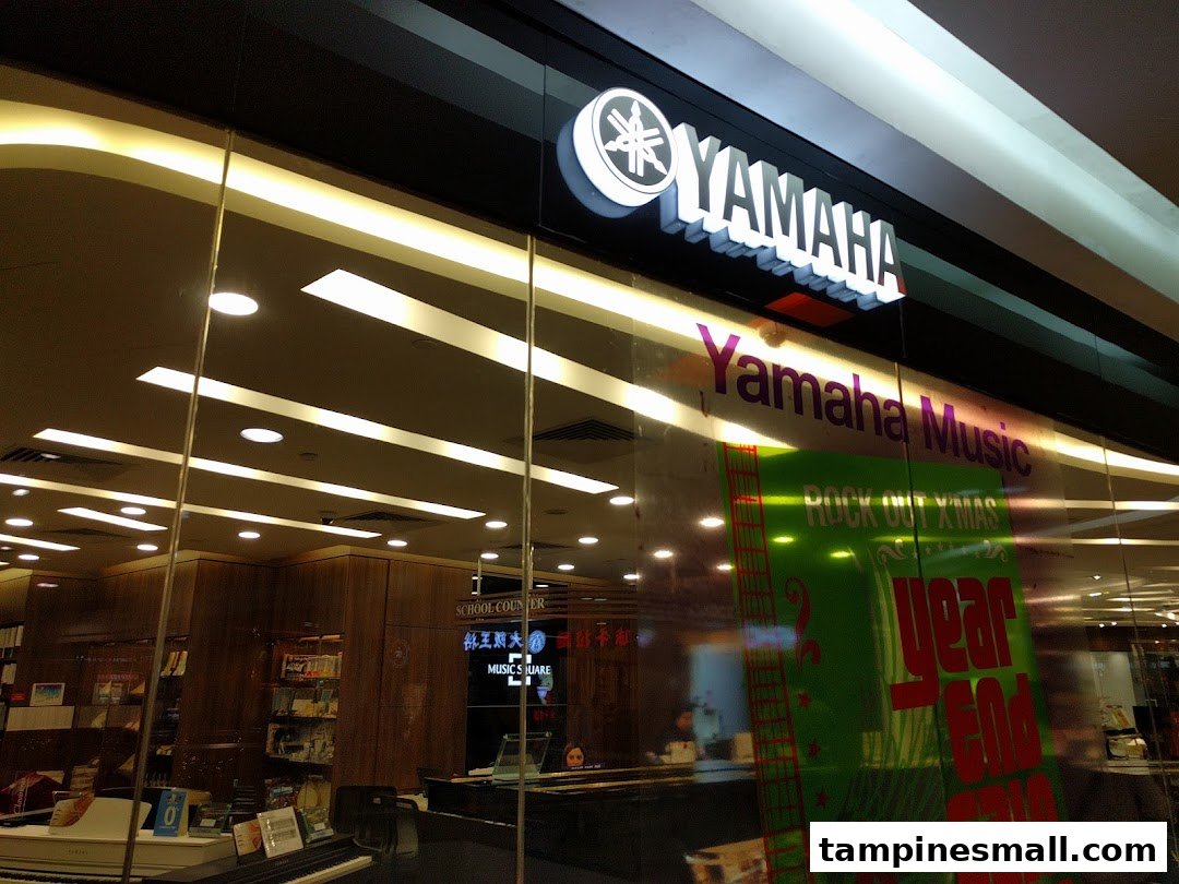 The glass facade of Yamaha Music School, showcasing its logo, interior, and musical instruments.