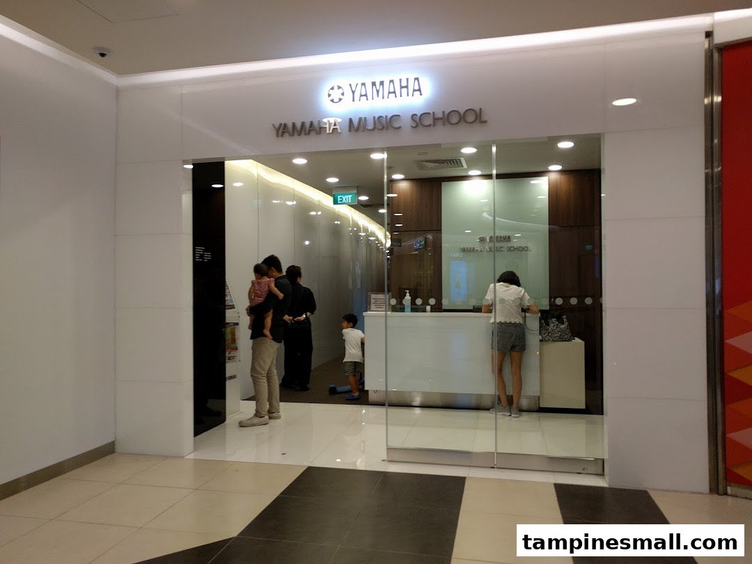The bright, modern entrance of Yamaha Music School with people inside and outside.