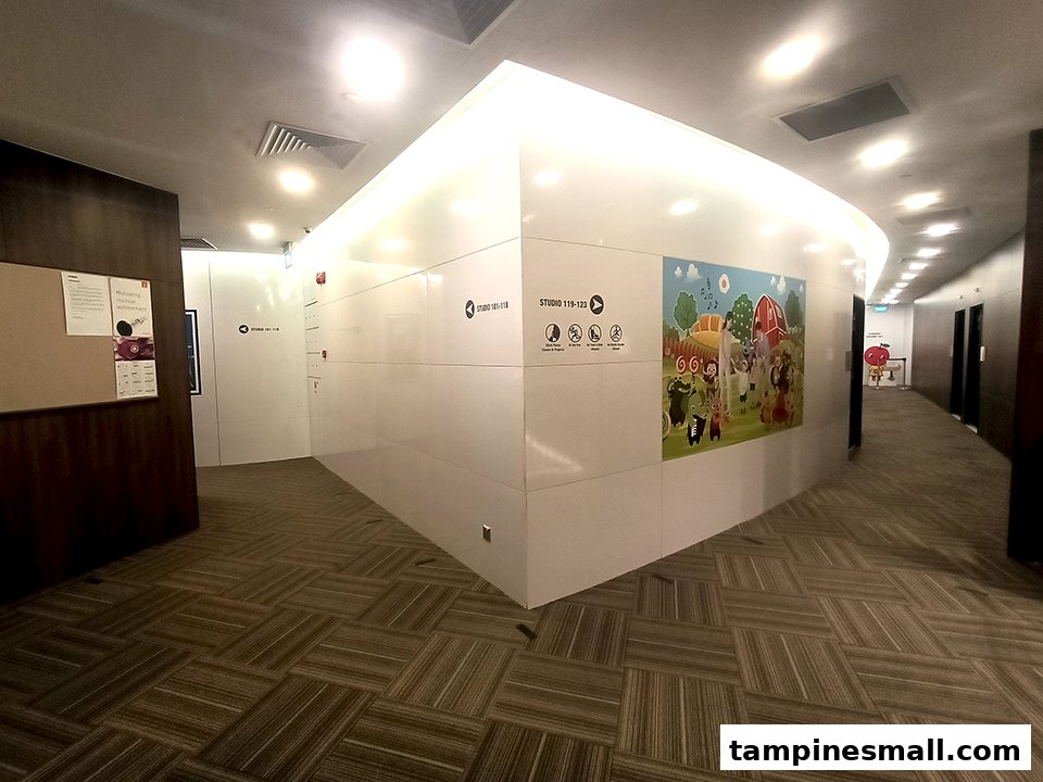 A bright, modern hallway at Yamaha Music School with studio entrances and a colorful children's mural.