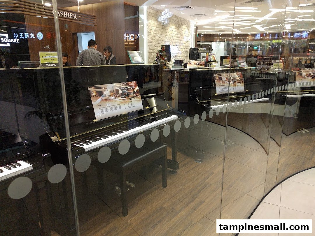 Interior view of Yamaha Music School showcasing pianos and a cashier counter through a glass facade.