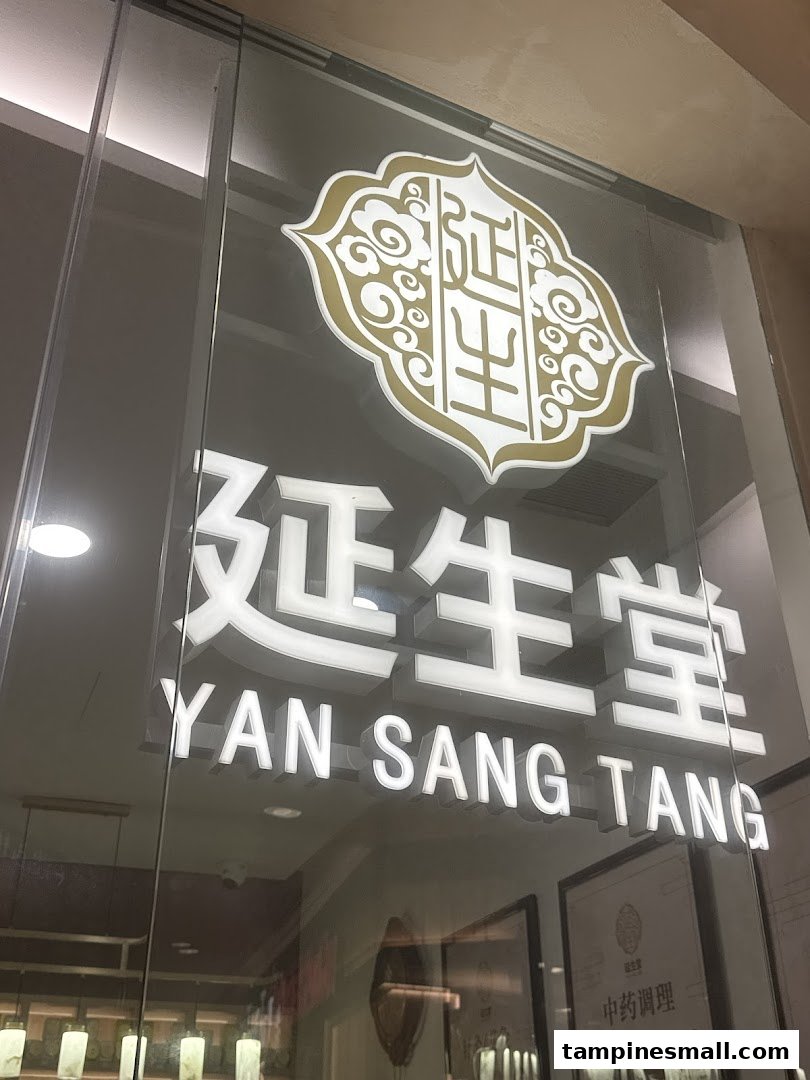 Close-up of the illuminated 'Yan Sang Tang' shop front signage on a glass door.