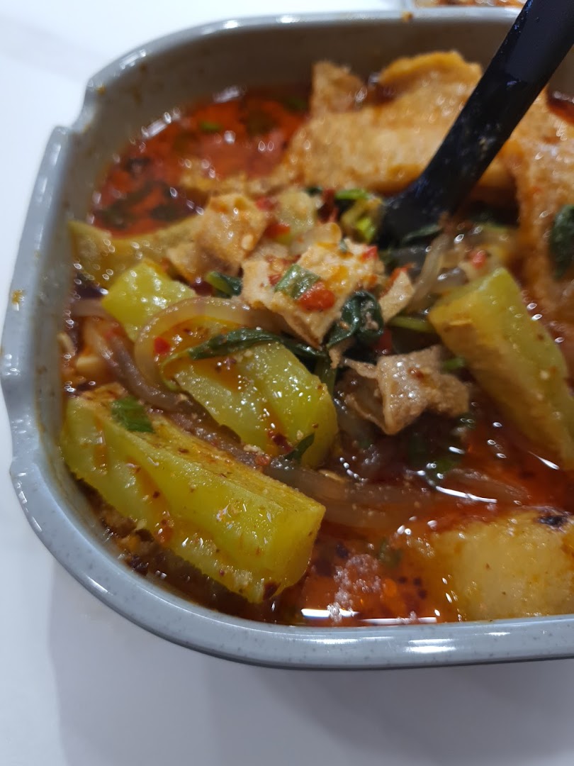 A close-up of a vibrant bowl of spicy Mala Tang with various ingredients.