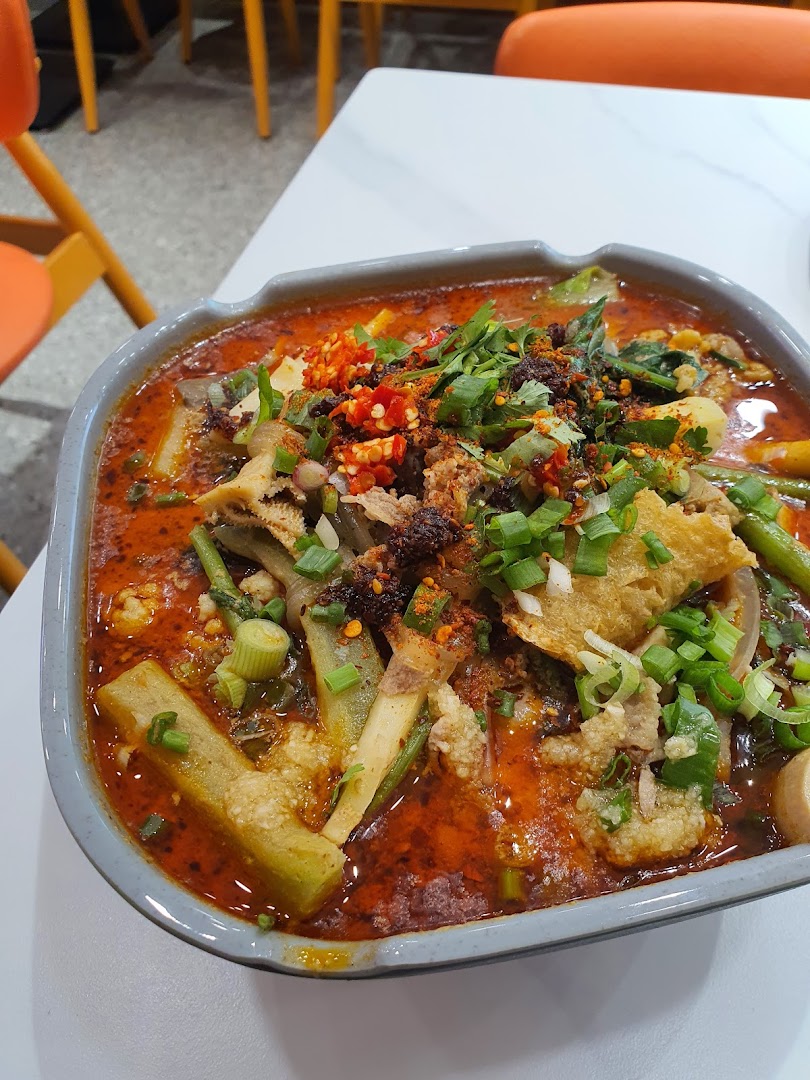 A vibrant bowl of spicy Mala Tang with various ingredients and fresh toppings.