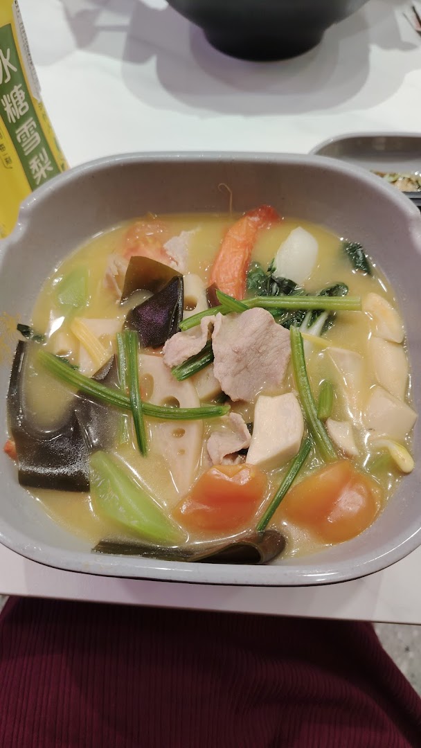 A vibrant bowl of Mala Tang soup filled with various fresh ingredients and meats.