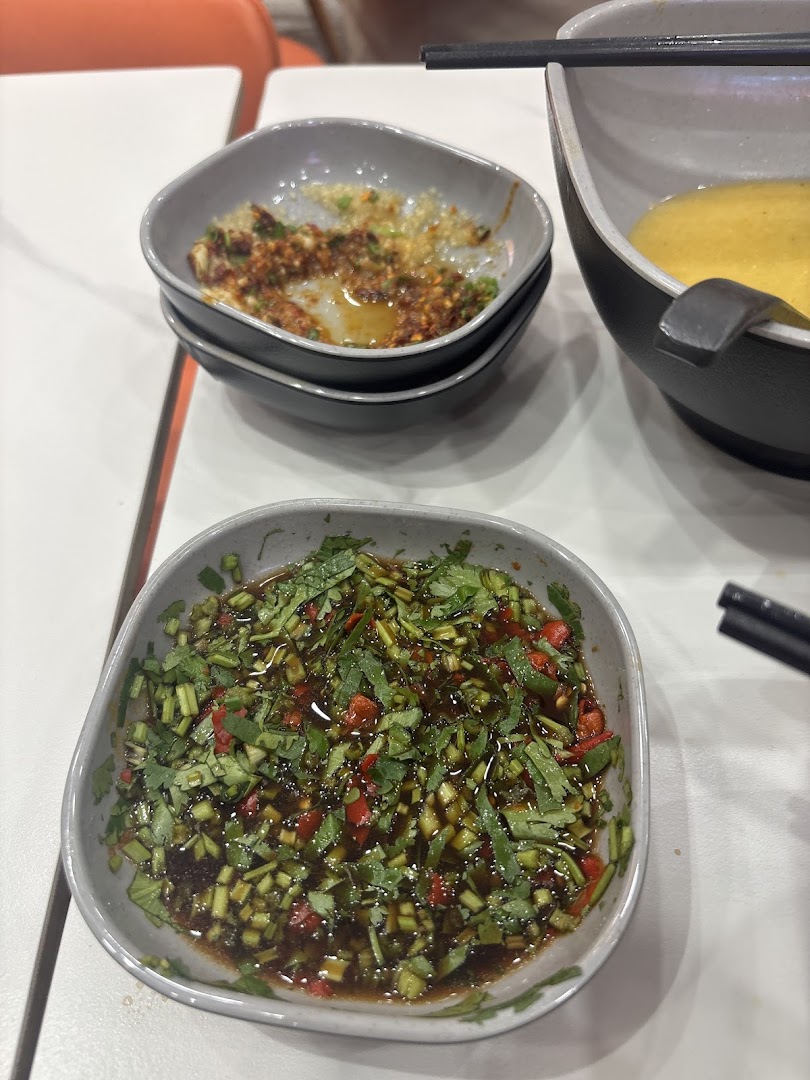 Close-up of flavorful dipping sauces and condiments on a table at Yang Guo Fu Mala Tang.