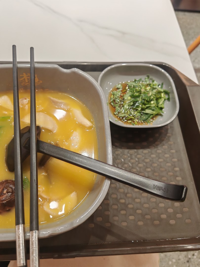 A close-up of a delicious bowl of Mala Tang with a side dish, chopsticks, and spoon on a tray.