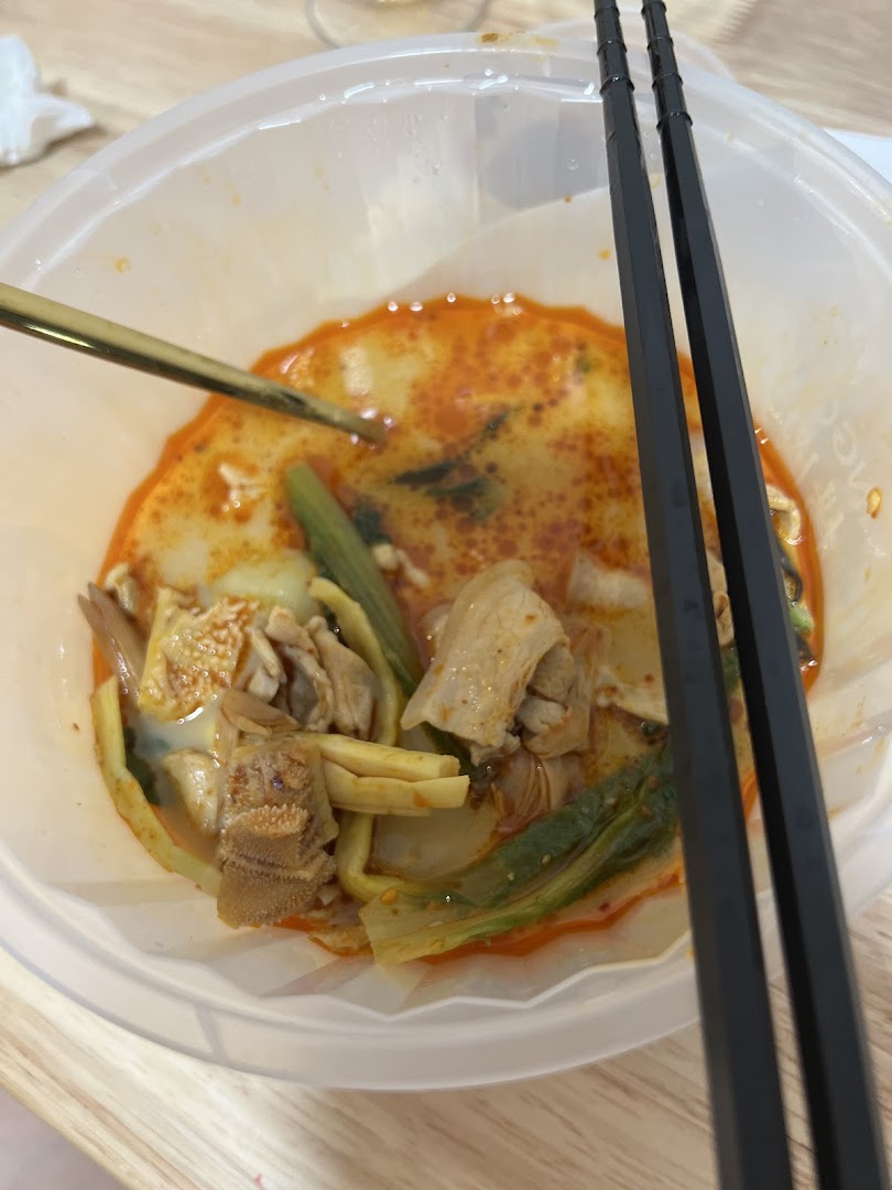 A close-up of a delicious bowl of mala tang with various ingredients and chopsticks.