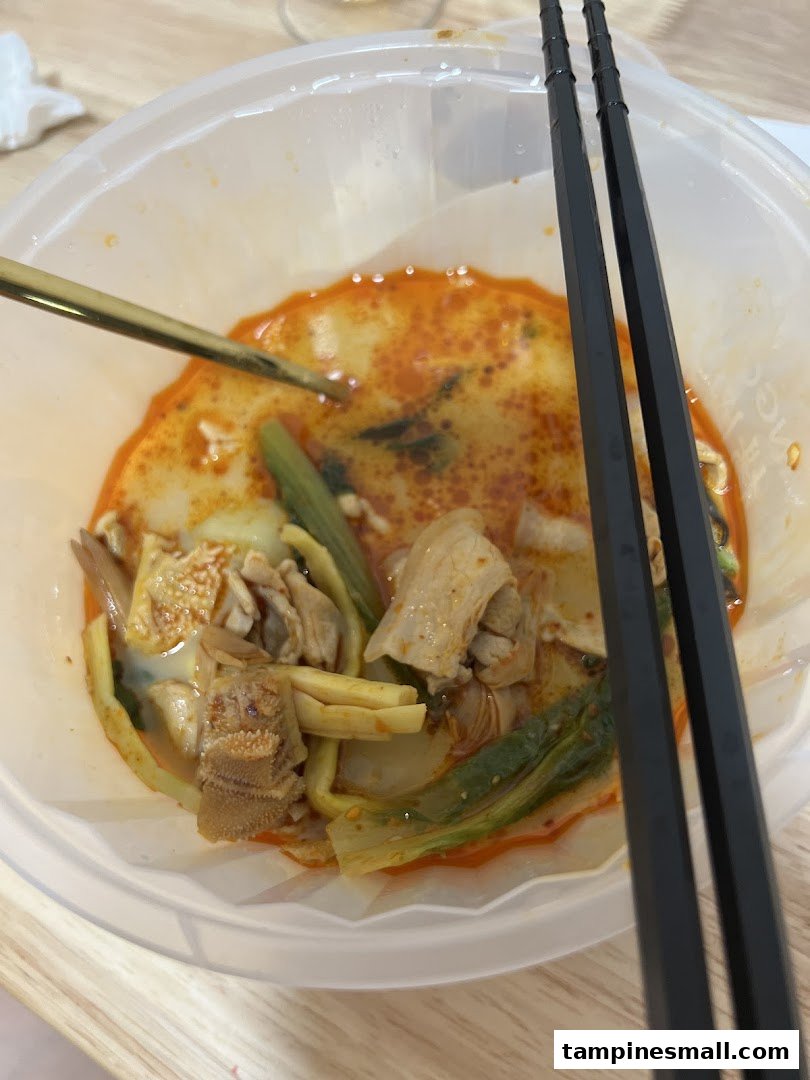 A close-up of a delicious bowl of mala tang with various ingredients and chopsticks.