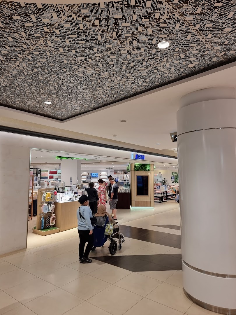 Customers browse the inviting entrance of Isetan Tampines, showcasing a variety of lifestyle products.