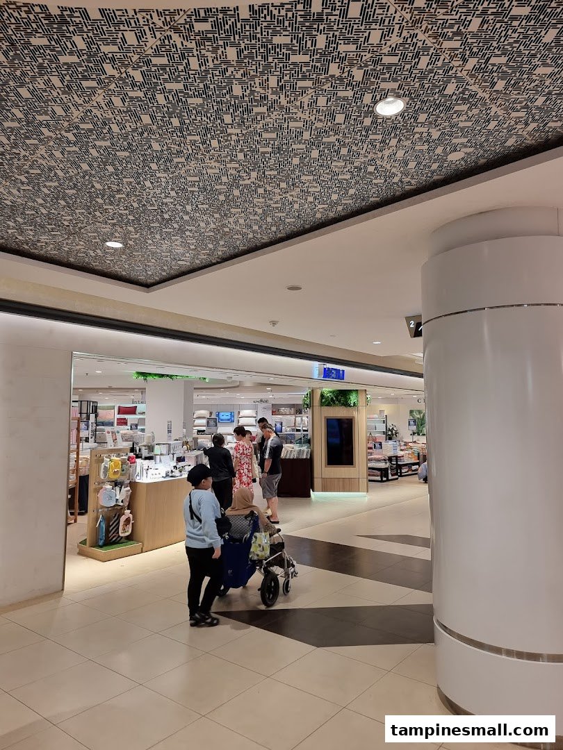 Customers browse the inviting entrance of Isetan Tampines, showcasing a variety of lifestyle products.