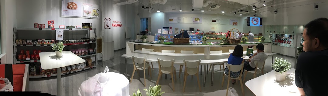 Interior of Boulangerie Asanoya, a bright bakery and cafe featuring display counters, seating, and retail shelves.