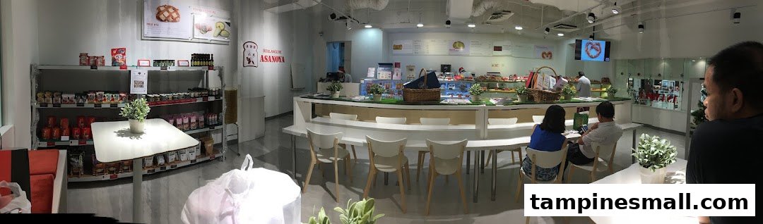 Interior of Boulangerie Asanoya, a bright bakery and cafe featuring display counters, seating, and retail shelves.