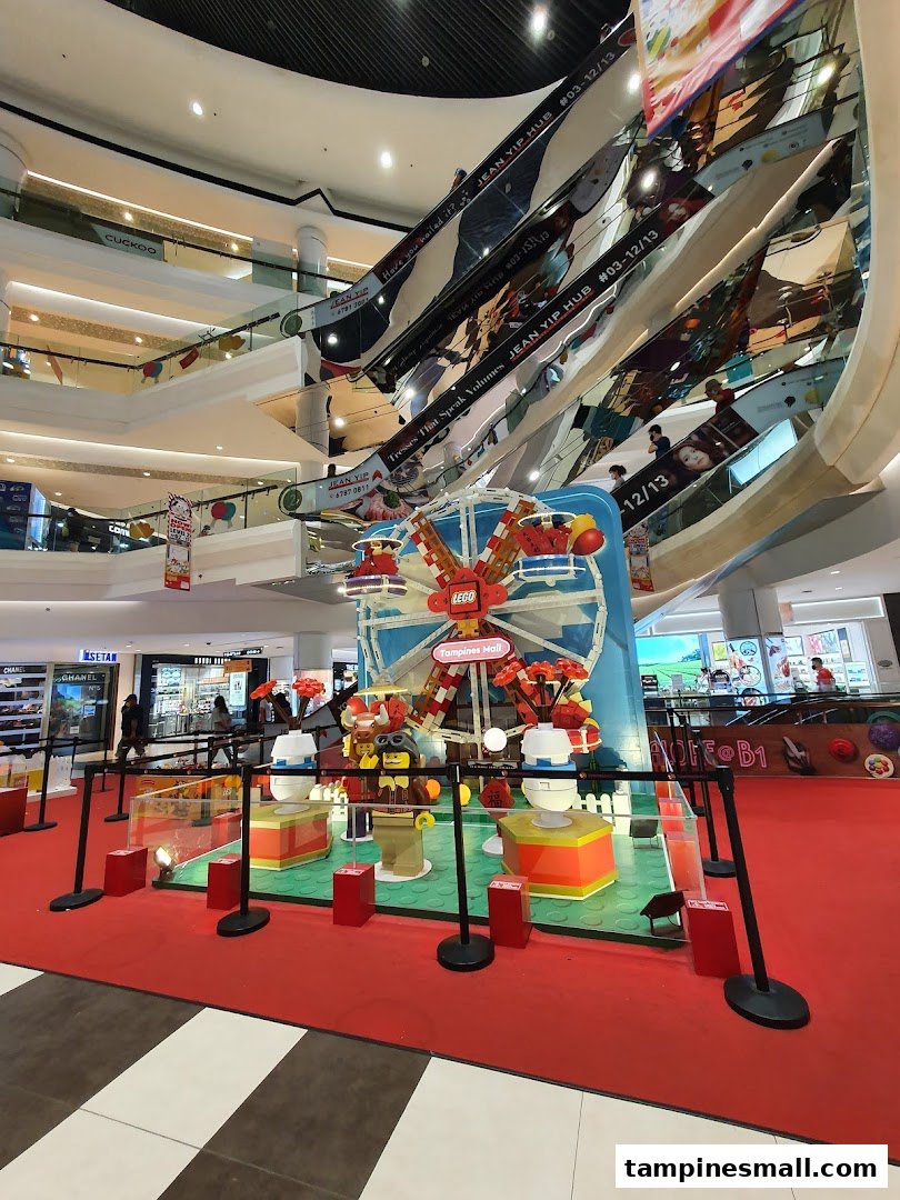 A vibrant LEGO display featuring a Ferris wheel in the multi-level atrium of Isetan Tampines mall.