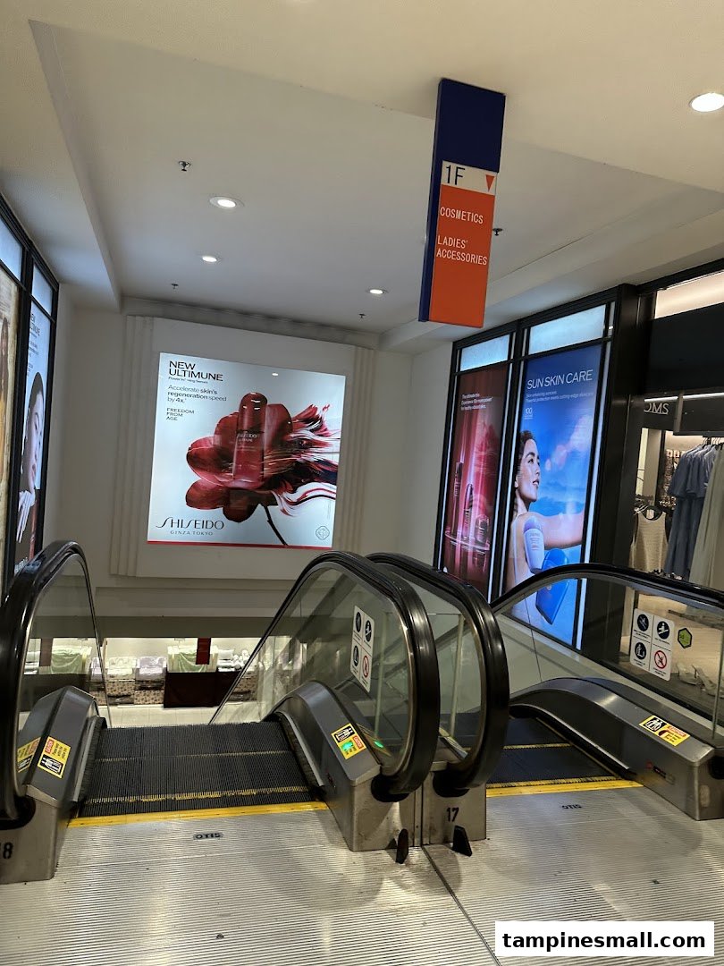An escalator leading to the 1st floor, featuring beauty and fashion departments with prominent Shiseido ads.