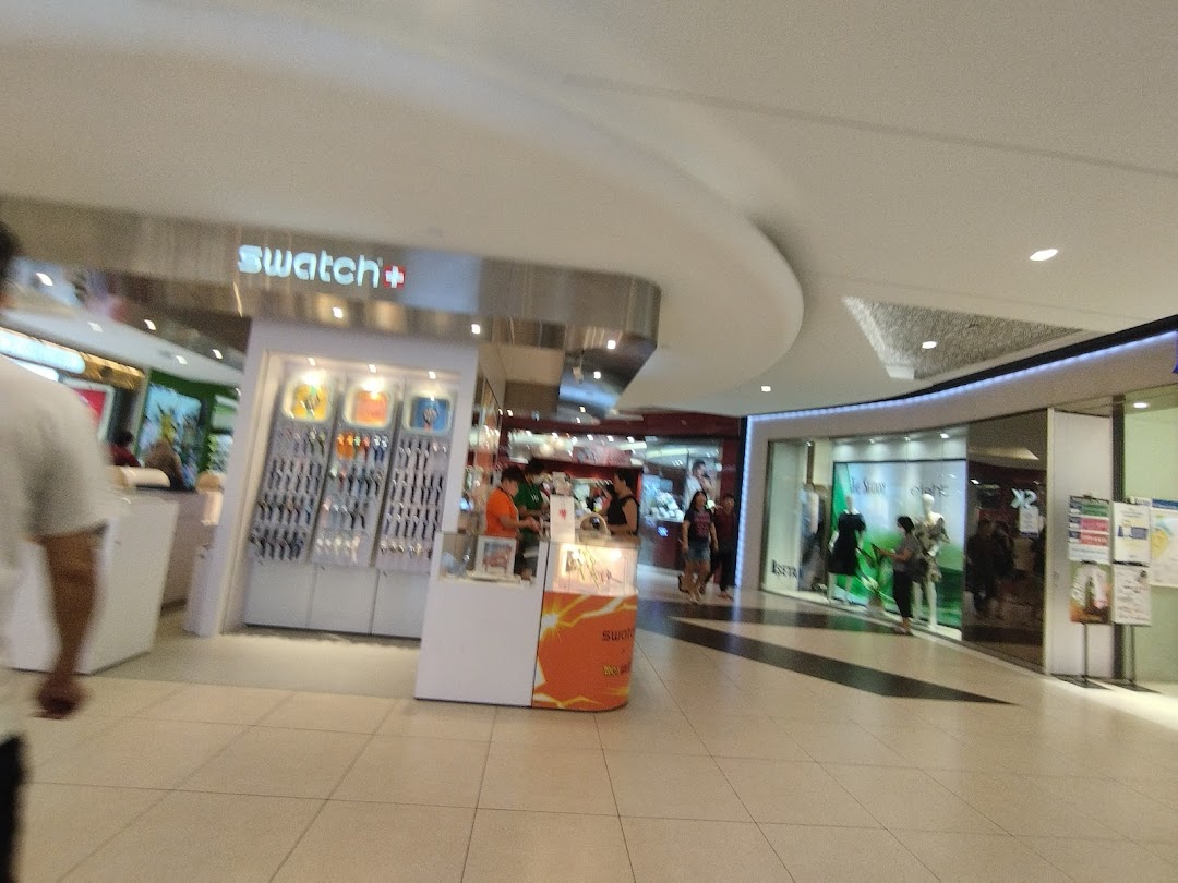 A bustling mall interior featuring the Swatch store and other retail entrances.