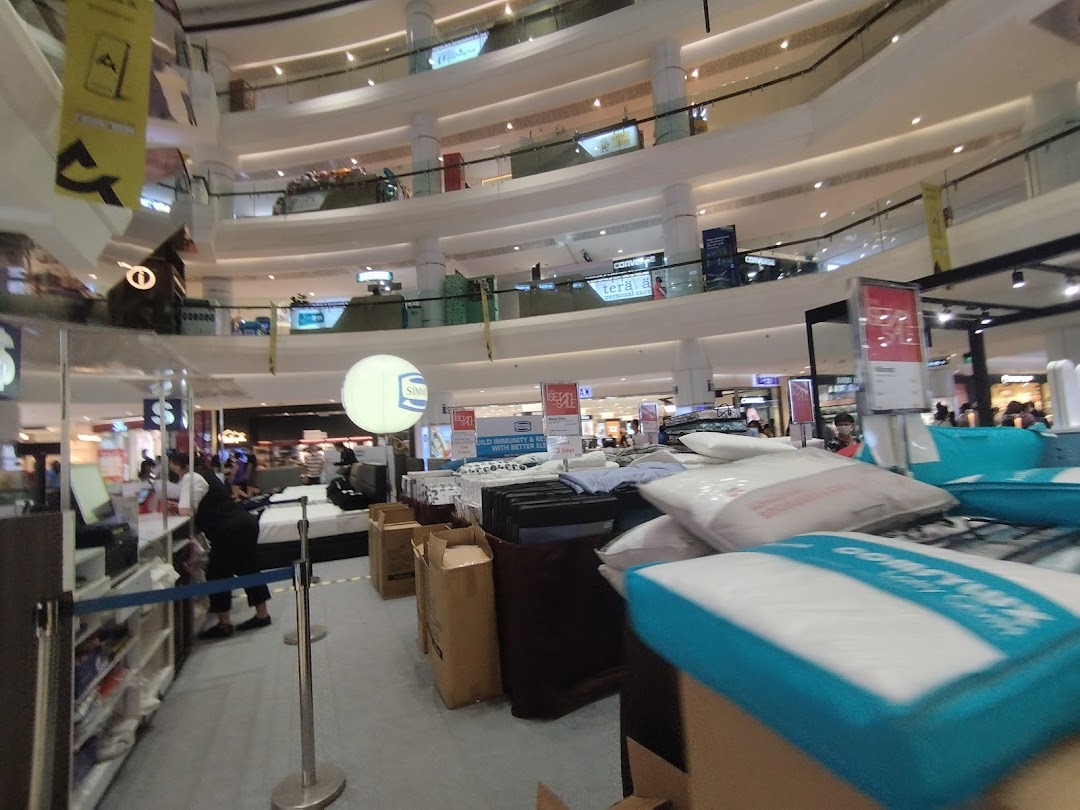 An interior view of a multi-level department store, showcasing bedding and home goods displays.