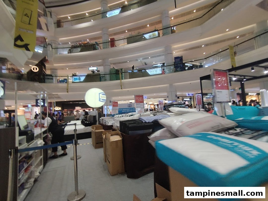 An interior view of a multi-level department store, showcasing bedding and home goods displays.