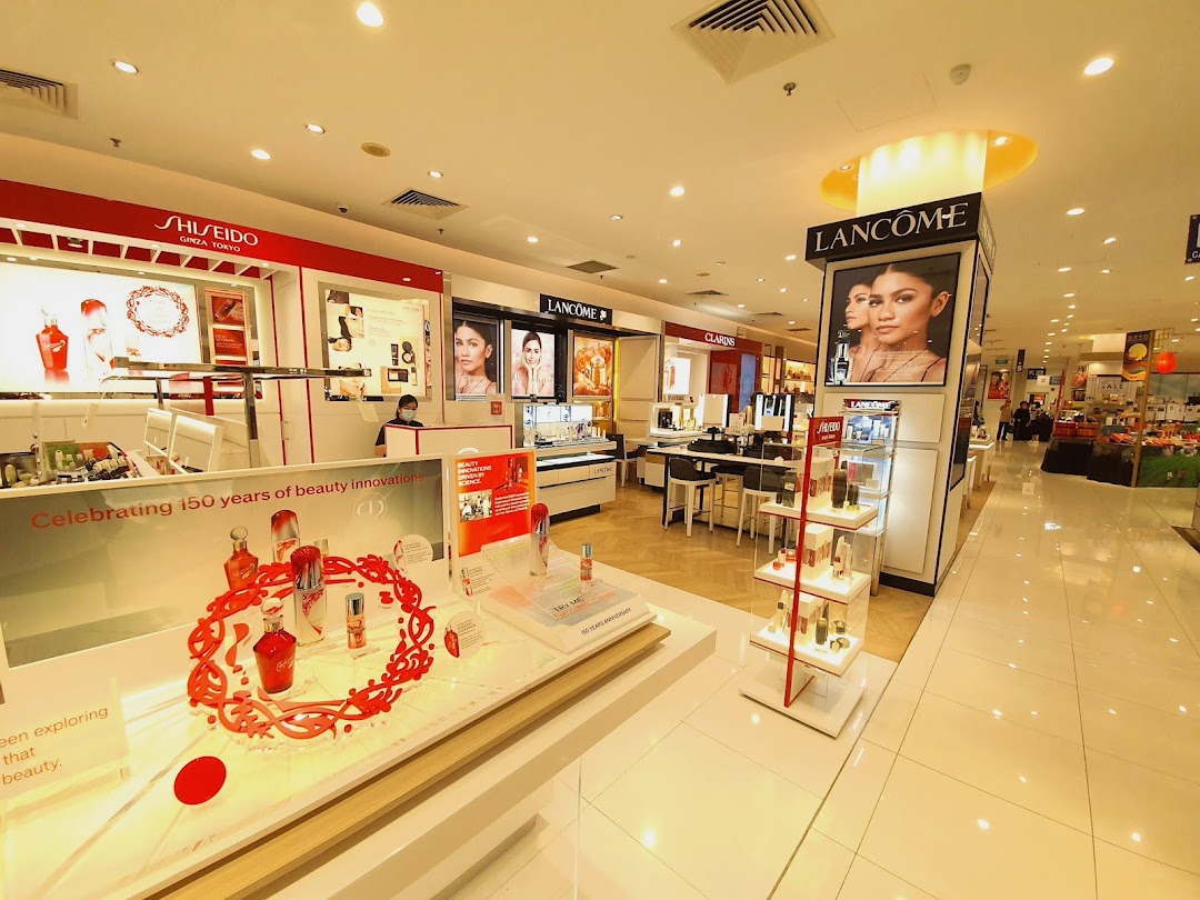 A brightly lit beauty department featuring premium brands like Shiseido, Lancôme, and Clarins.