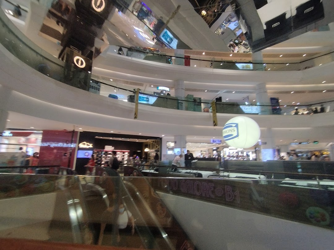 An expansive interior view of a multi-level shopping mall with escalators and various retail outlets.