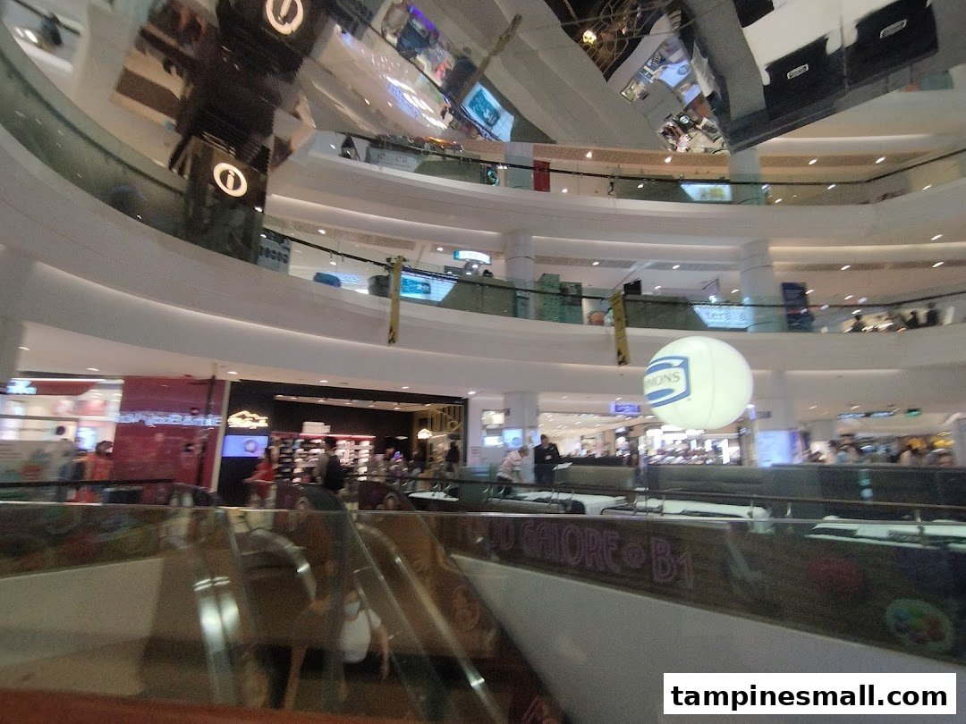 An expansive interior view of a multi-level shopping mall with escalators and various retail outlets.