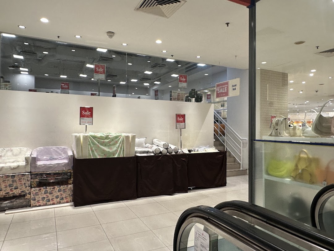 An interior view of Isetan showing a sale area with various items and escalators.