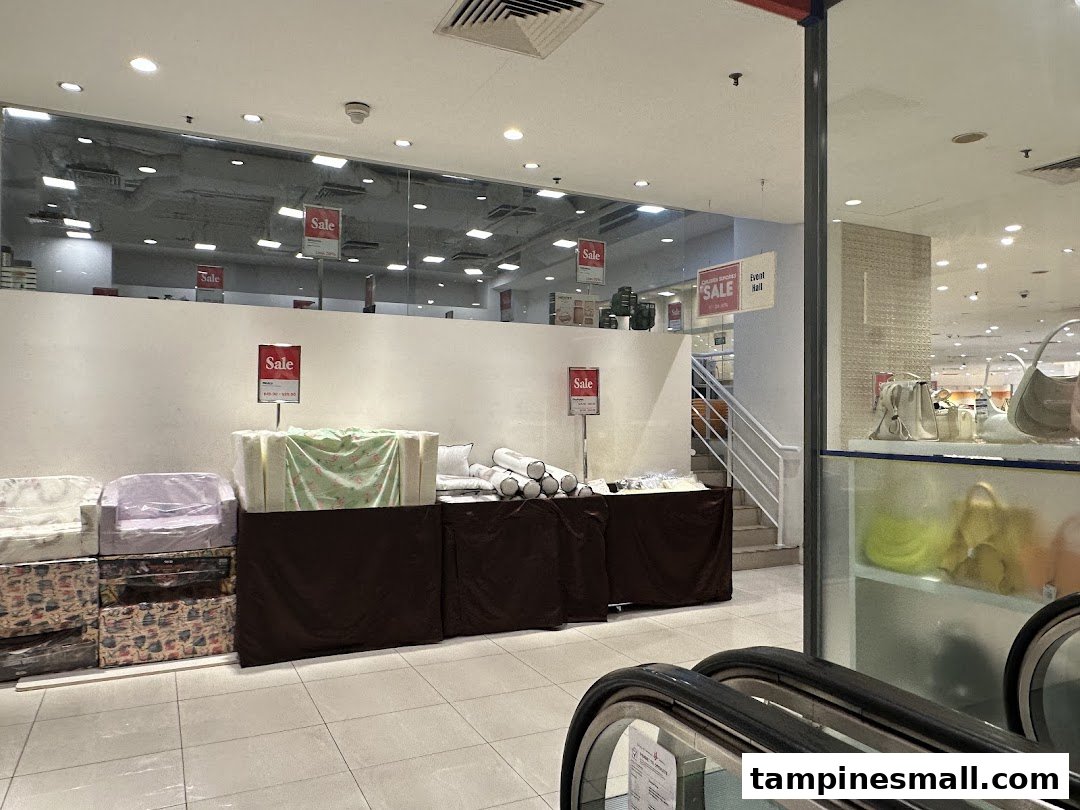 An interior view of Isetan showing a sale area with various items and escalators.