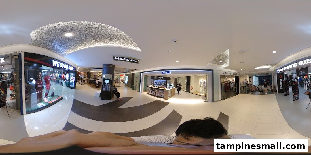 An interior view of a modern shopping mall showcasing various retail outlets including Isetan, Weston Corp, and Mango.