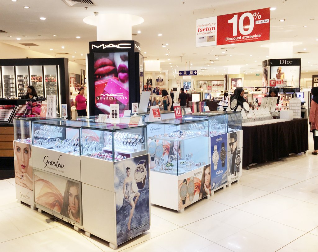 Department store interior with beauty and jewelry displays, including MAC, Dior, and Grandeur.