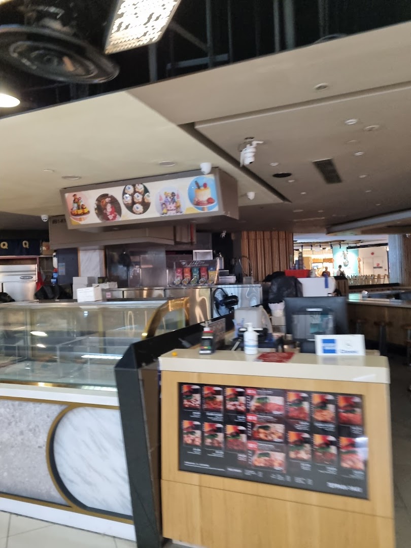 Interior view of Yolé at Tampines Mall, featuring the counter, display cases, and digital menu.