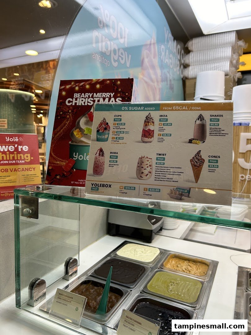 A Yolé frozen yogurt counter displaying a detailed menu board with various froyo options, shakes, and toppings.