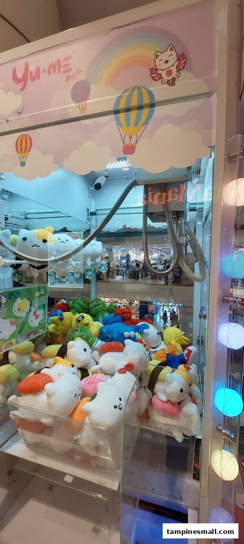A vibrant claw machine filled with various plush toys, including sushi-themed and character plushies.