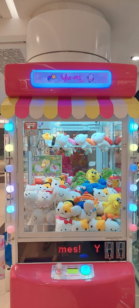 A vibrant pink Yume Claw machine filled with various cute plush toys, including cat-shaped and sushi-themed characters.