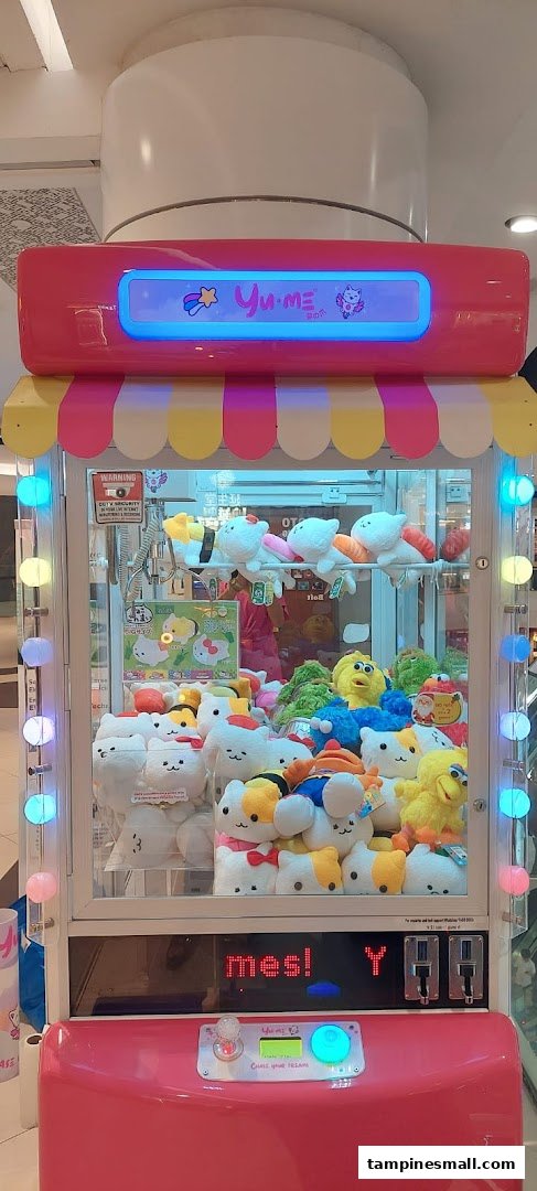 A vibrant pink Yume Claw machine filled with various cute plush toys, including cat-shaped and sushi-themed characters.