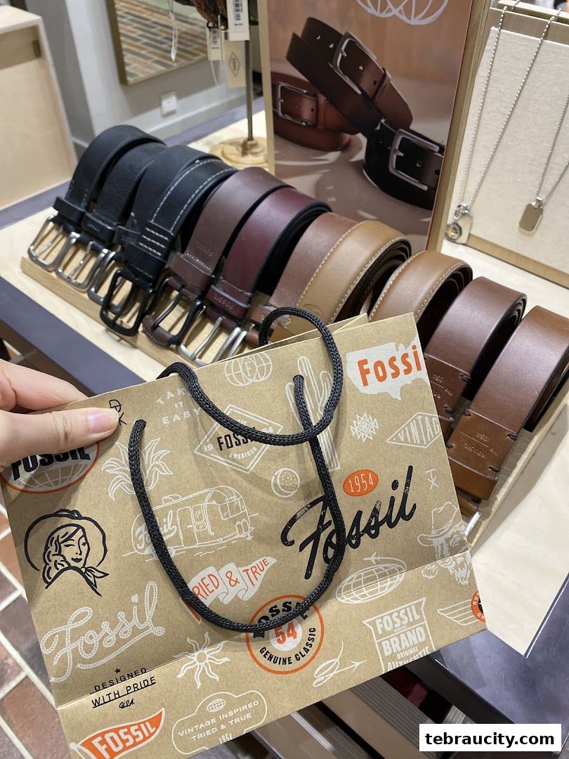 A display of various Fossil belts and a shopping bag with the Fossil logo.