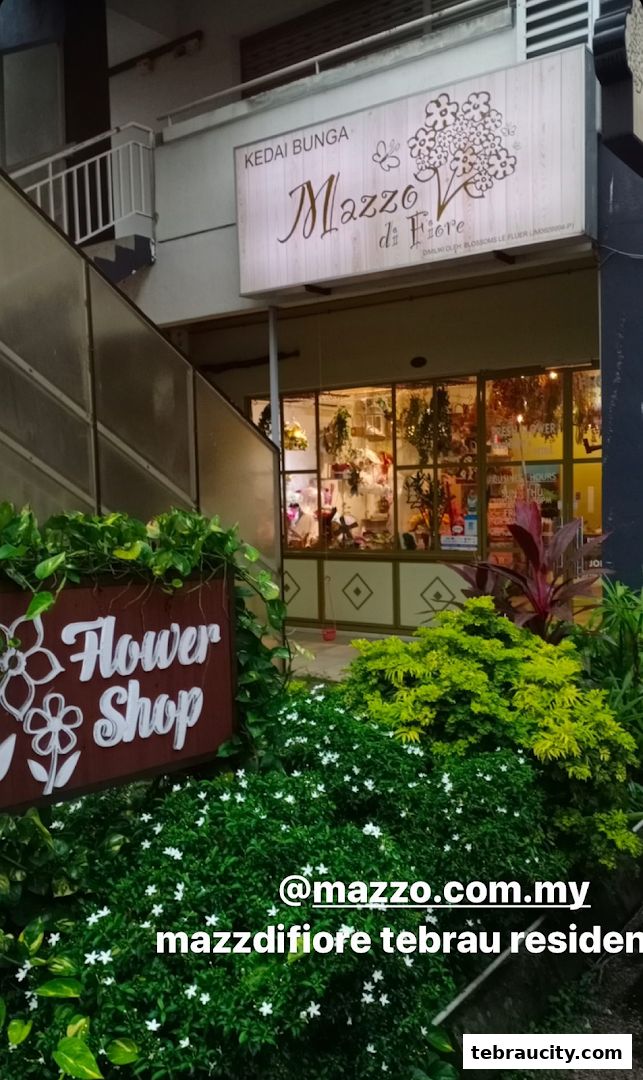 A flower shop entrance with a sign and lush greenery.