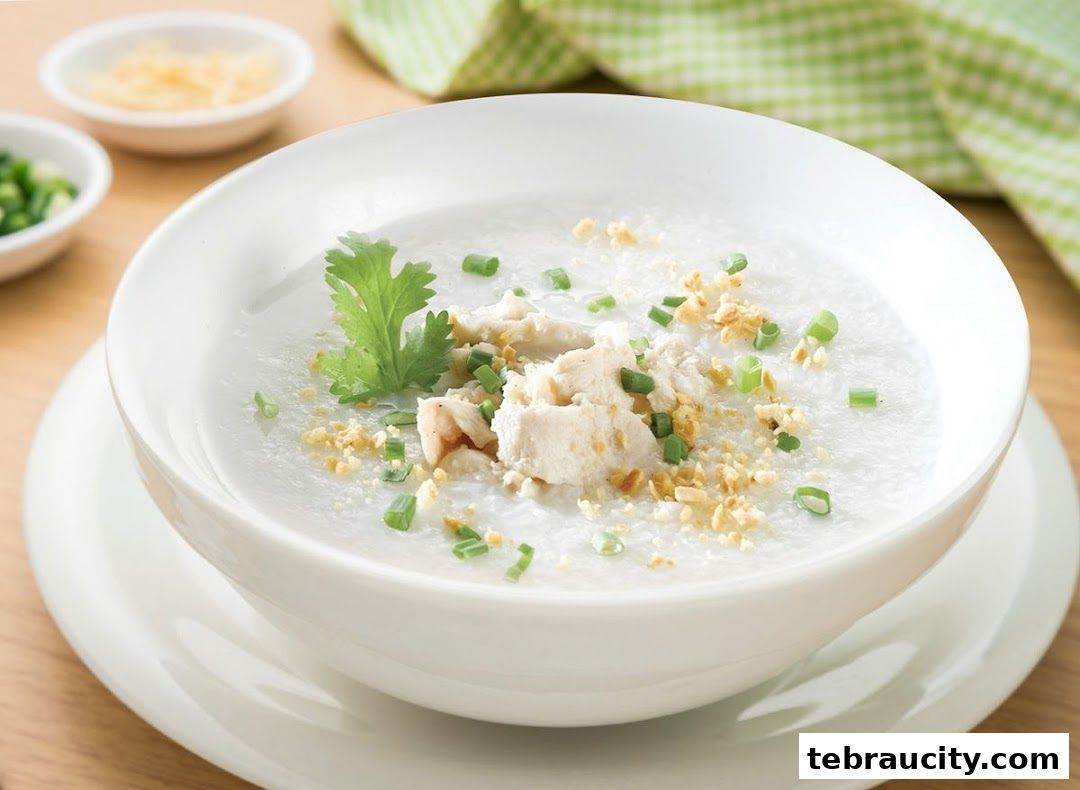 A bowl of congee topped with chicken, scallions, and fried garlic.